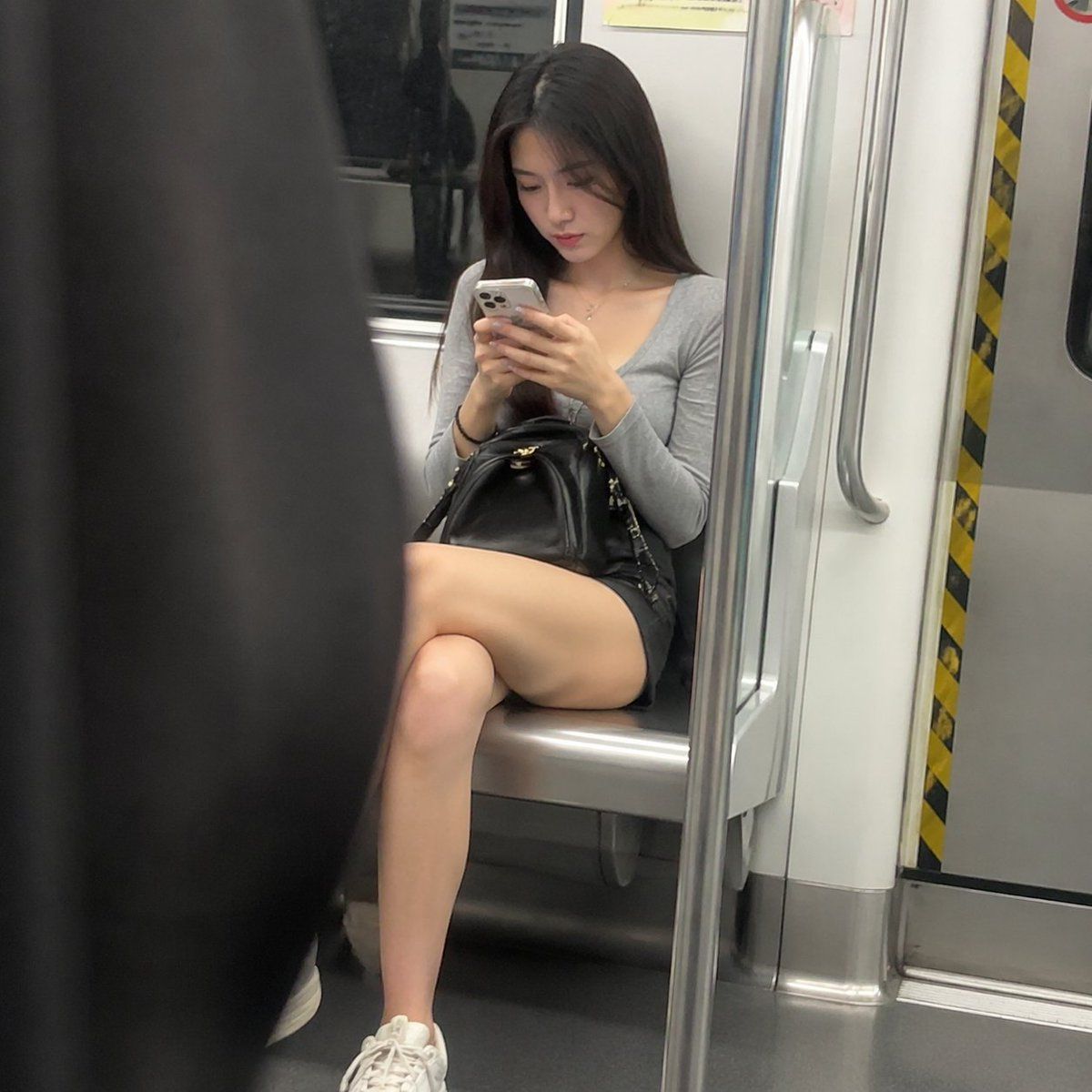 地铁车厢里看手机的美丽女人