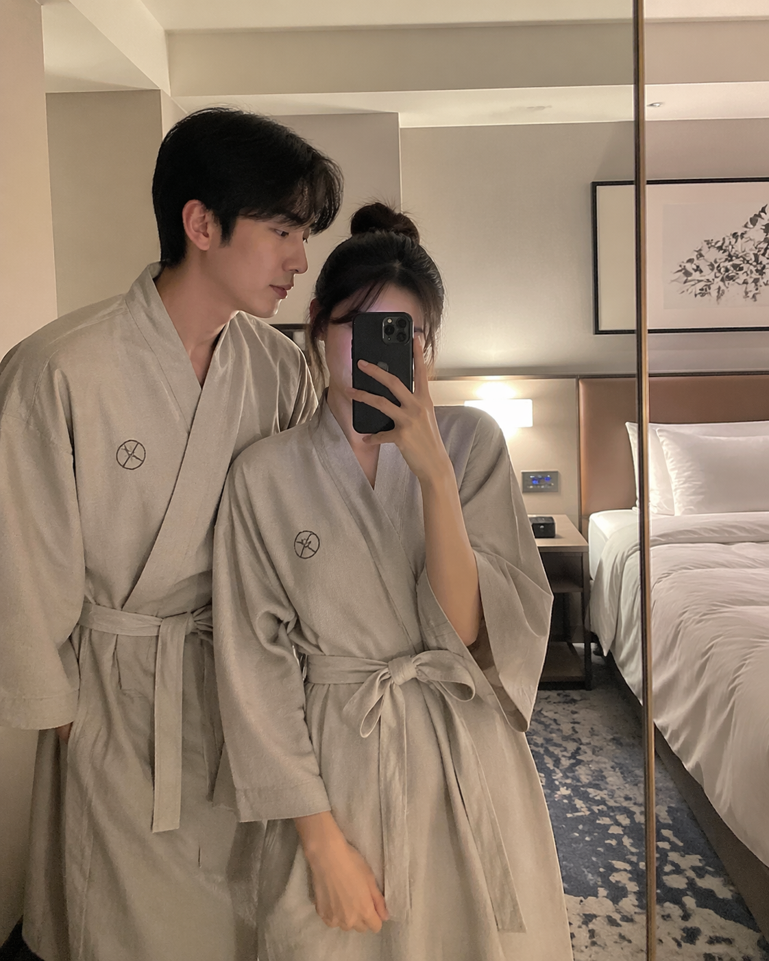 韩国酒店房间内,情侣穿着浴衣,站在镜子前自拍